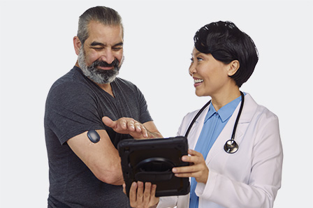 Health care provider helps a patient, with approval for continuous glucose monitor insurance coverage, insert a CGM device.  