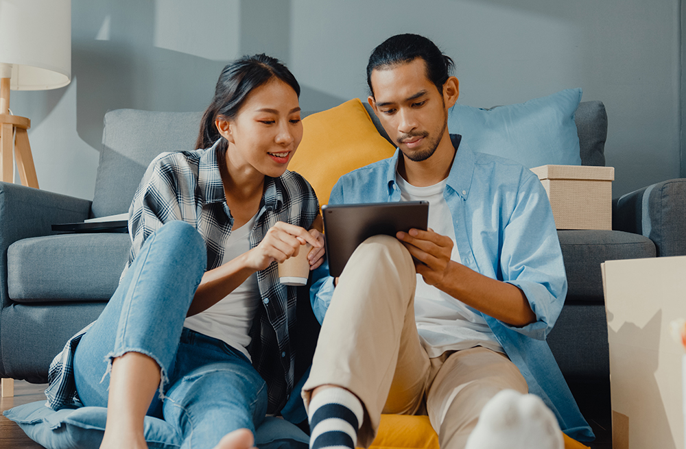 Young couple researching implantable CGM options on a tablet. 