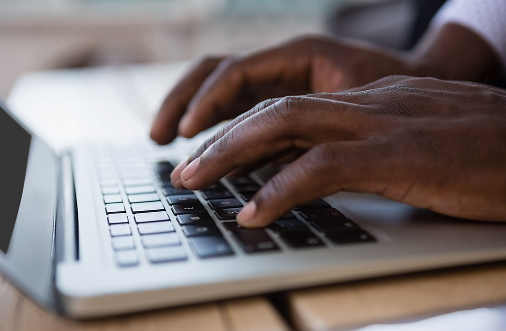 Man typing on the computer for CGM device information and how does a CGM work. 